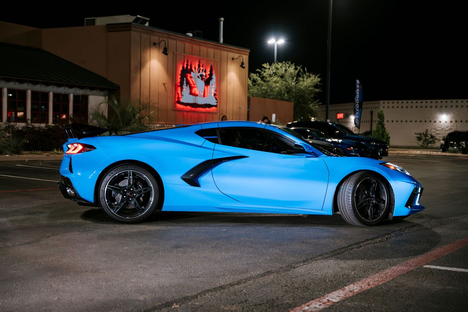 Light blue Chevrolet Corvette C8 showcasing its dramatic side profile at night.