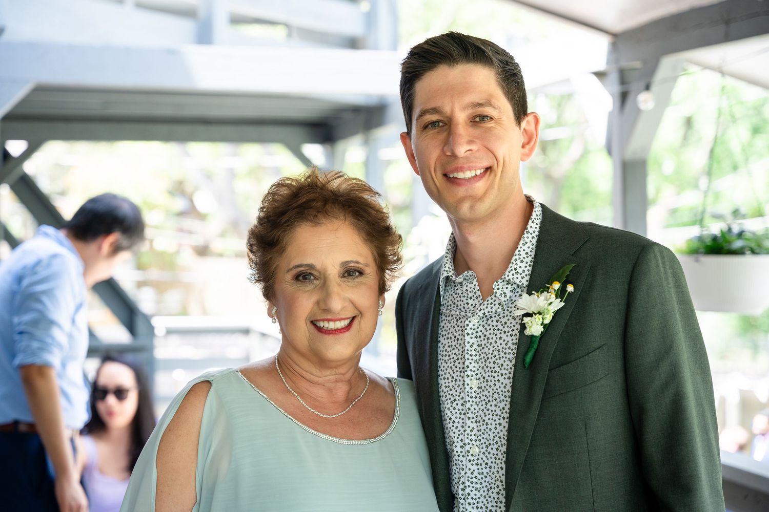 Sweet moment between dressed-up wedding attendees at outdoor celebration.