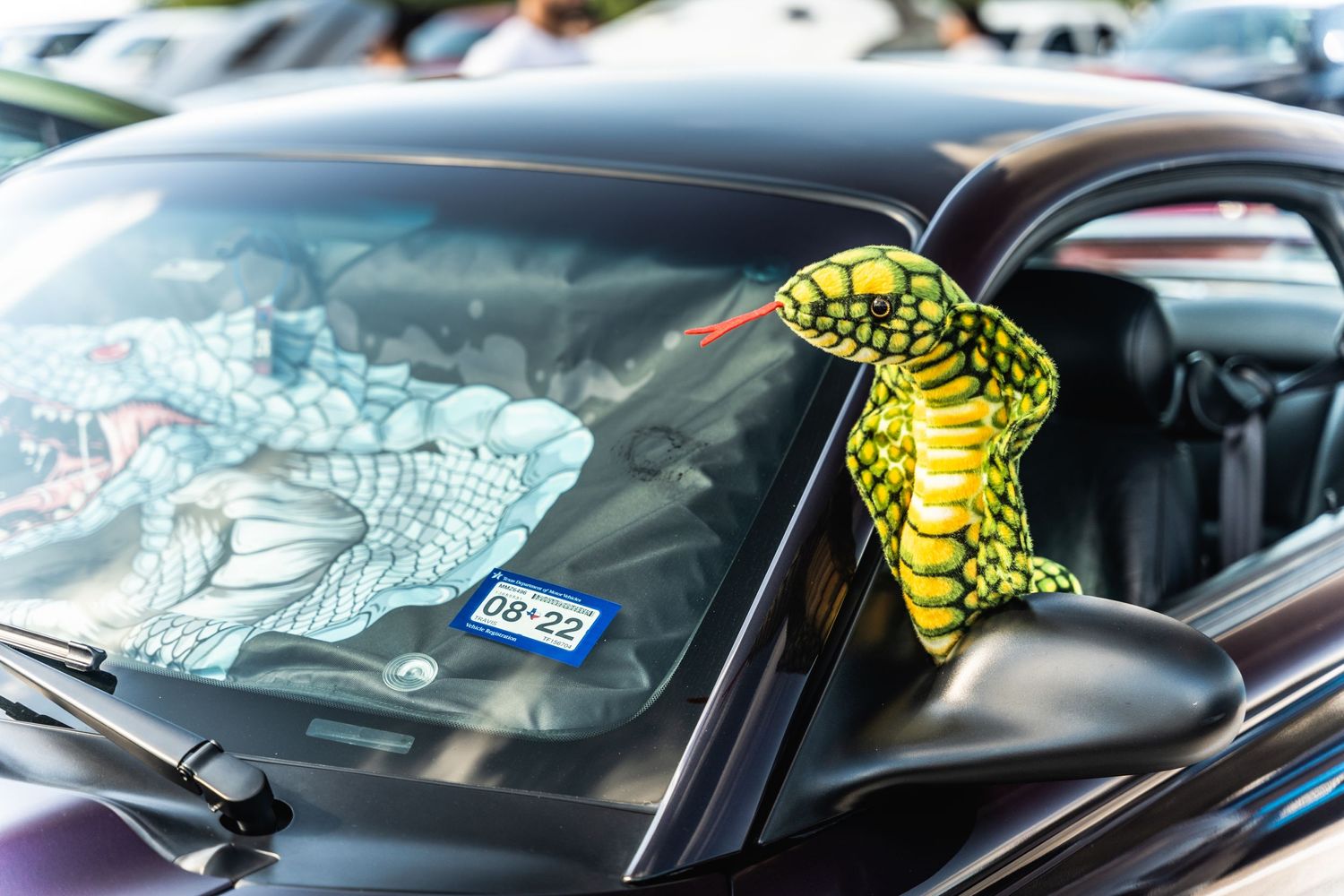 Decorative snake decal visible through the windshield of a black car.