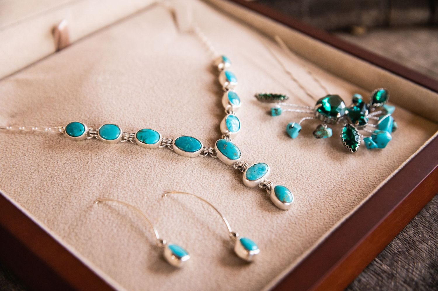 Turquoise jewelry set including necklace and earrings displayed on beige fabric.