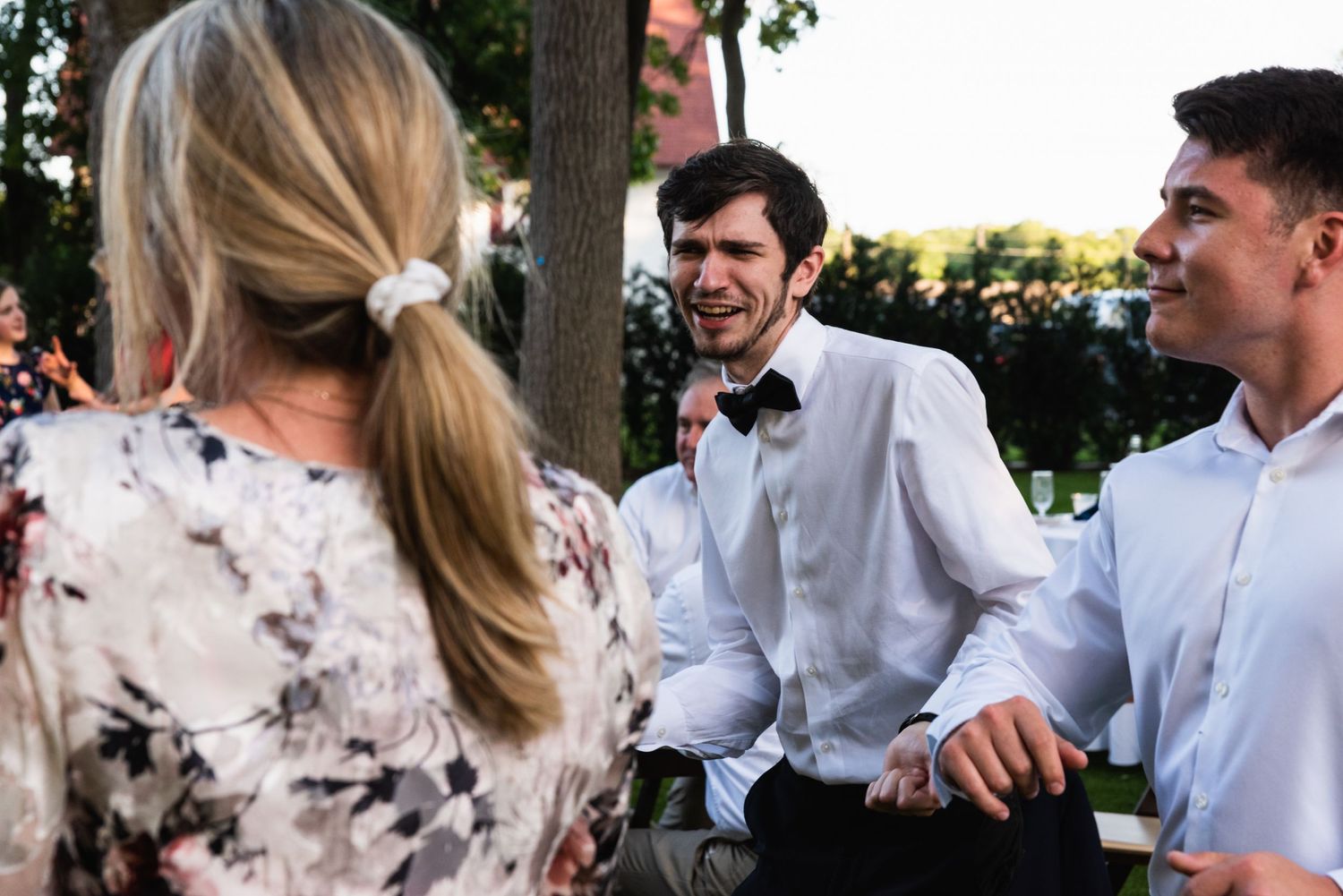 Guests enjoying conversation during an outdoor wedding reception with rustic decor.