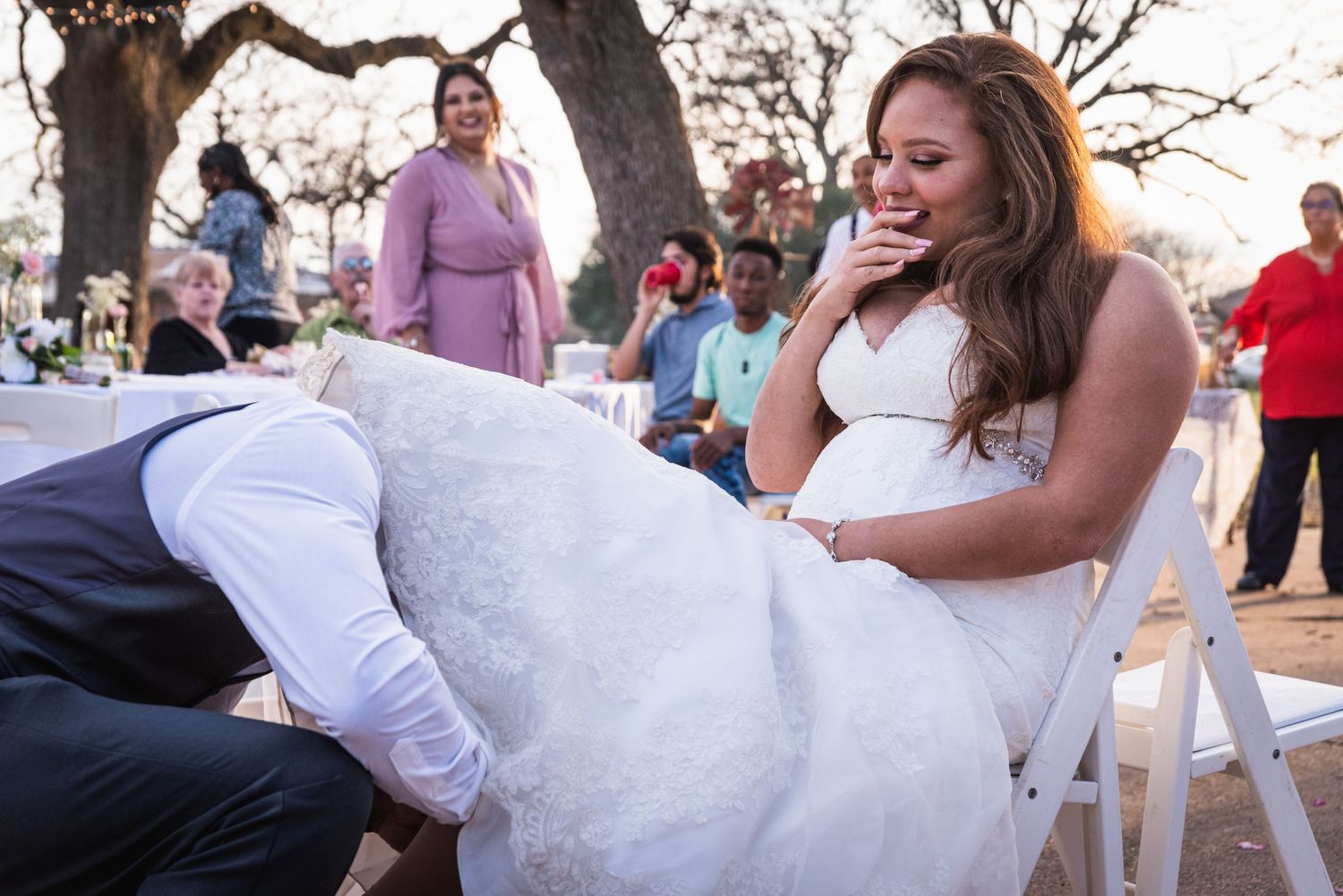 Candid moment of joy and laughter during a wedding ceremony at an outdoor venue.