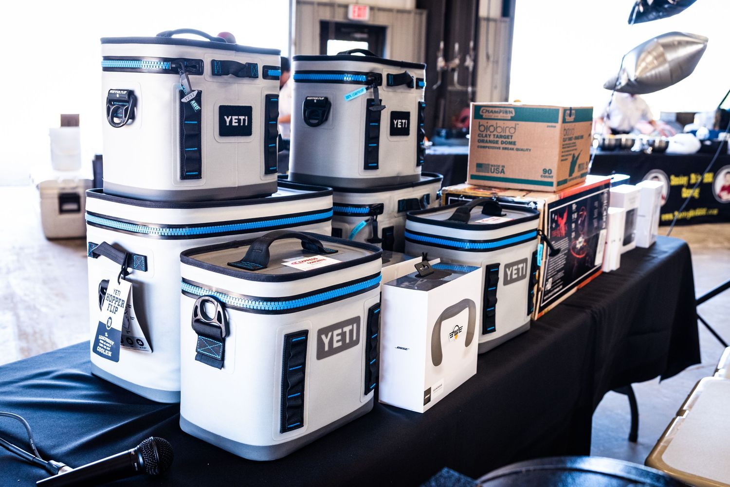 Display of white and blue YETI coolers arranged on a black table.