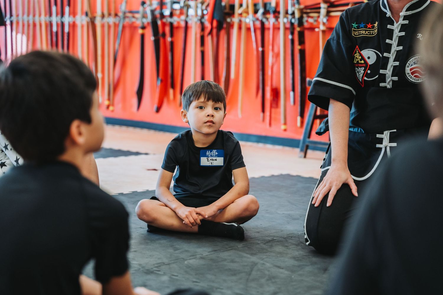 Training session in a martial arts studio with orange walls and hanging equipment.