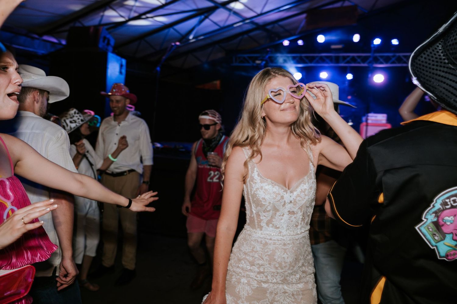 A joyful bride dances at her reception in a fitted lace wedding gown.
