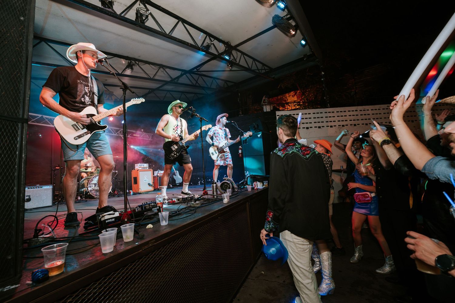 Live band performing on elevated stage with audience watching below.