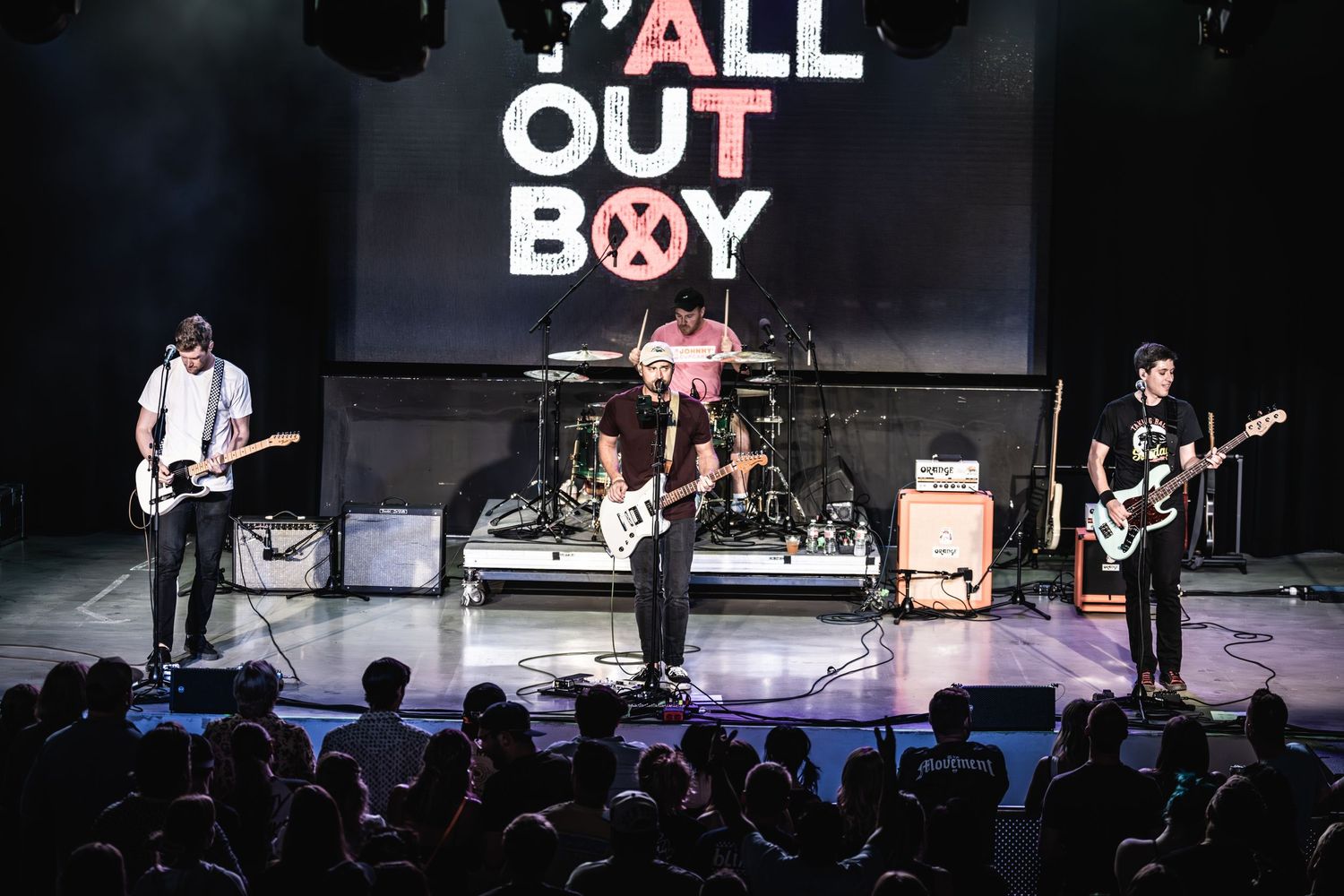 Four piece band performs live with Y'ALL OUT BOY backdrop and stage lighting.