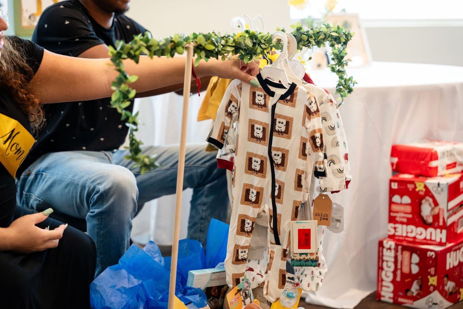 Baby clothes and decorative items on display at a shower celebration.