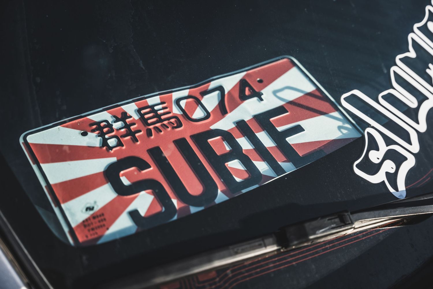 Japanese rising sun style Subif custom license plate with red and white design.