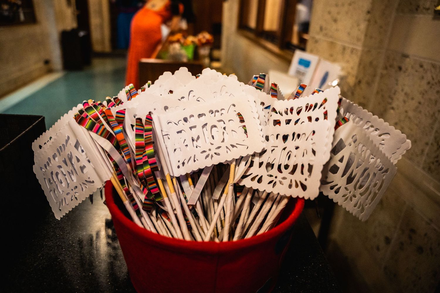 Small paper signs with handwritten text displayed in a red container.