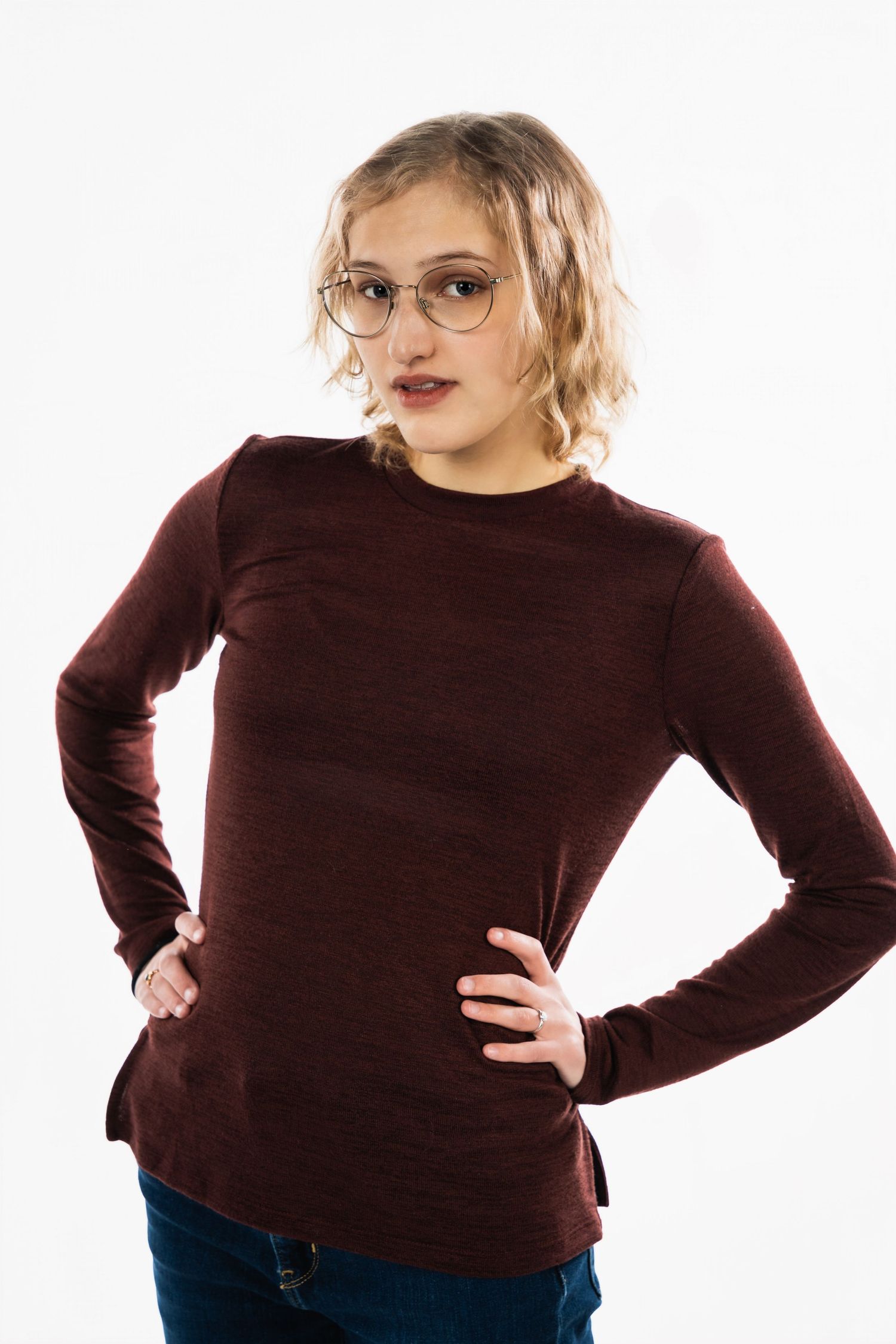 Portrait of a person in glasses and burgundy sweater against white background.