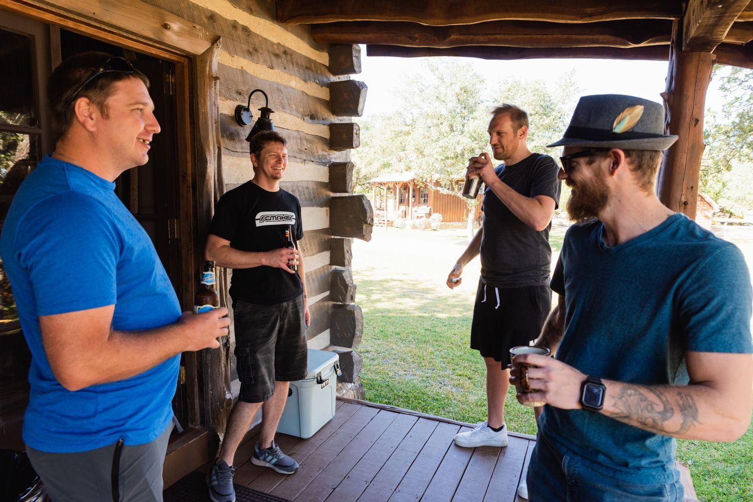 A group gathers on a rustic wooden porch for casual conversation.