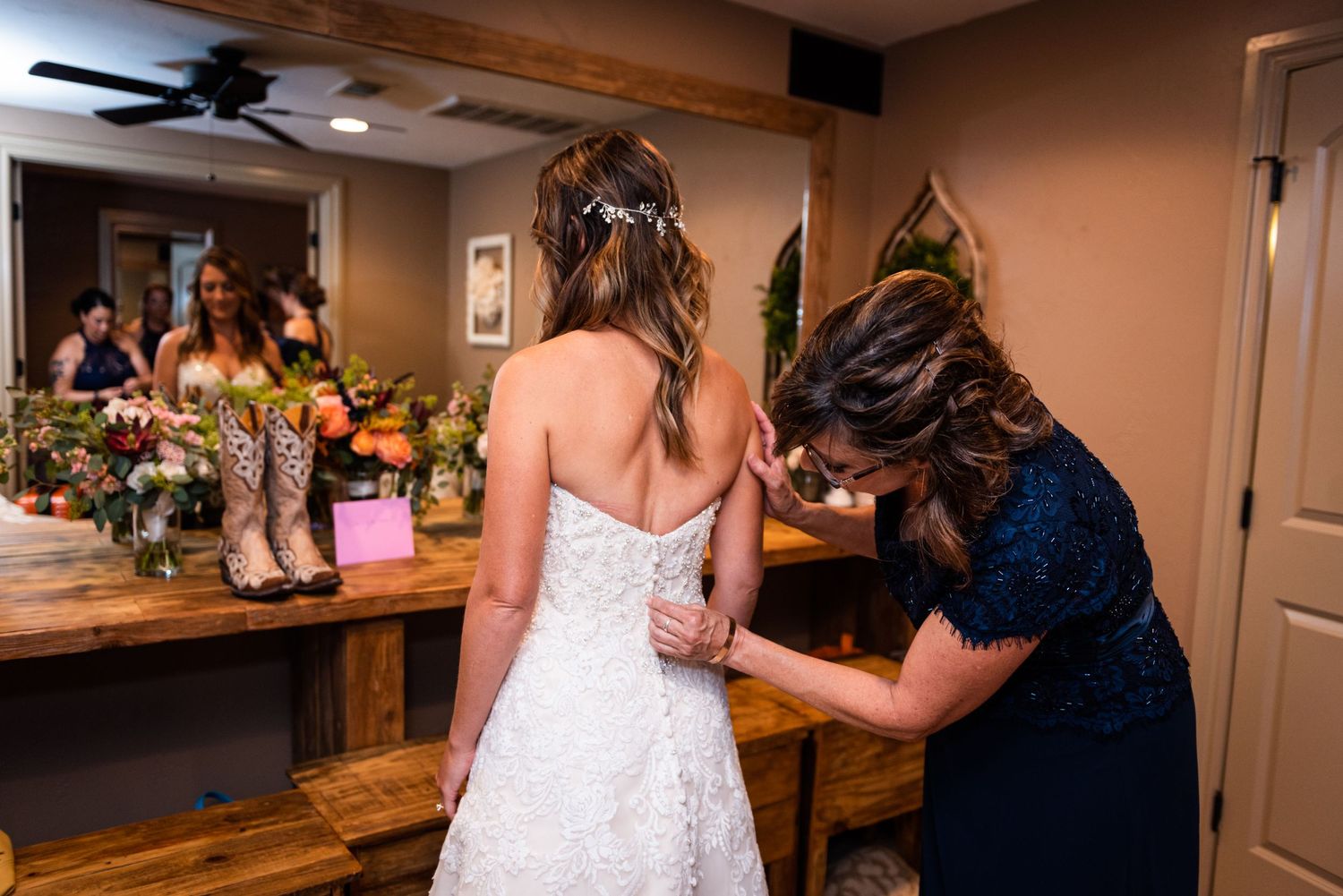 A behind-the-scenes moment of final dress adjustments before the wedding ceremony.