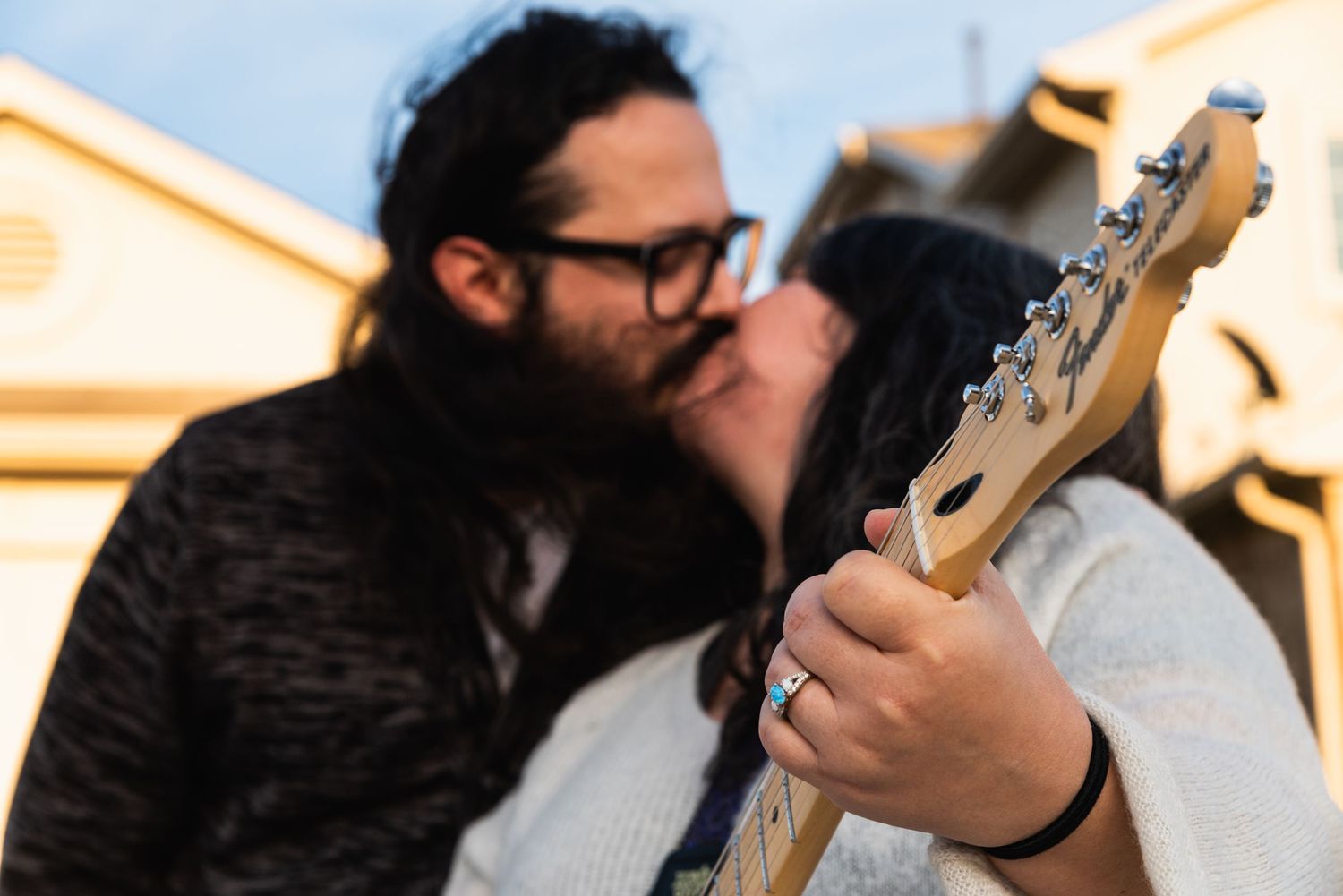 Close-up shot of hands playing an electric guitar during an intimate outdoor moment.