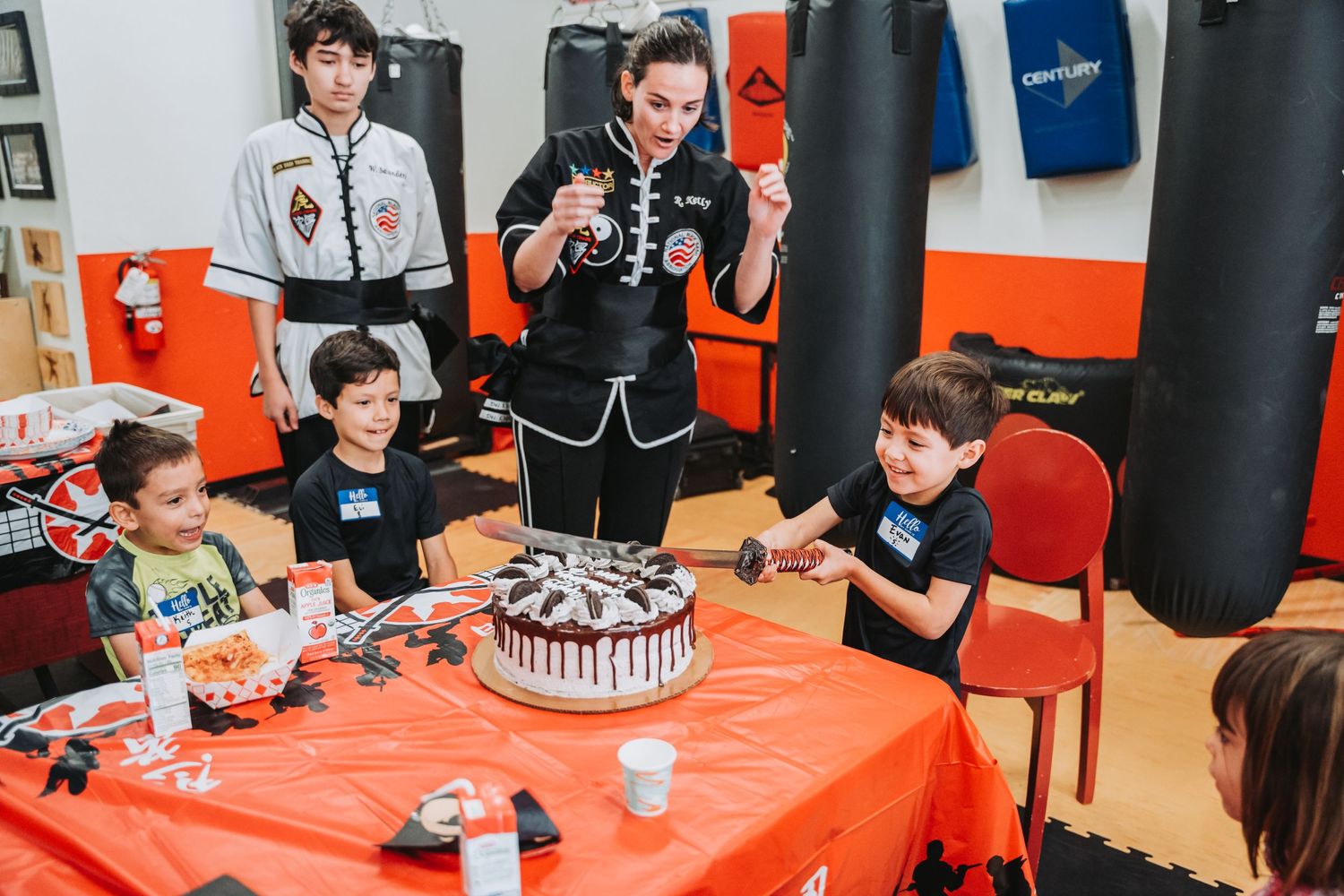Birthday celebration with chocolate cake and party decorations in martial arts studio.