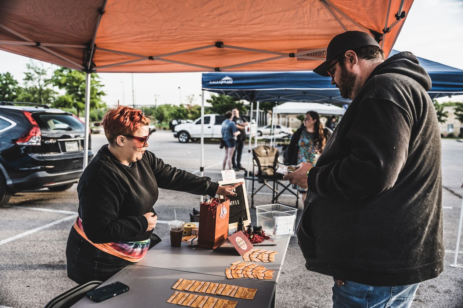 Vendor booth setup with merchandise display at an outdoor car event.