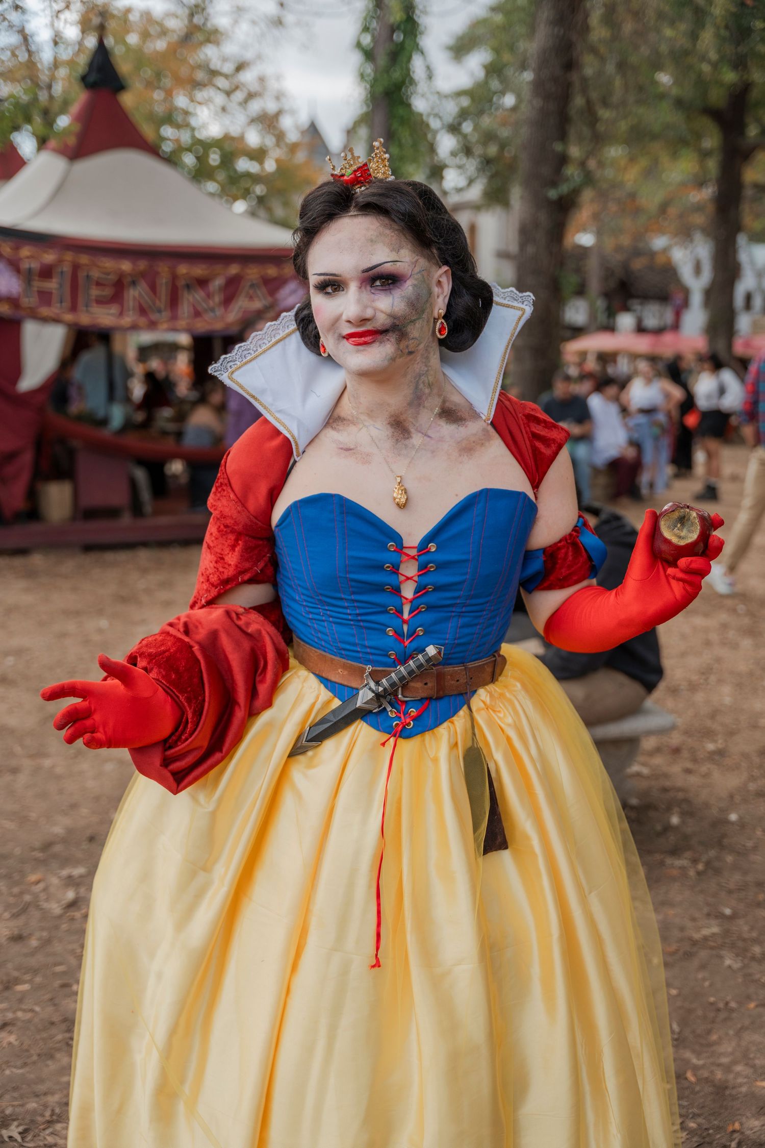 Renaissance fair performer in Snow White inspired costume with red and blue dress.