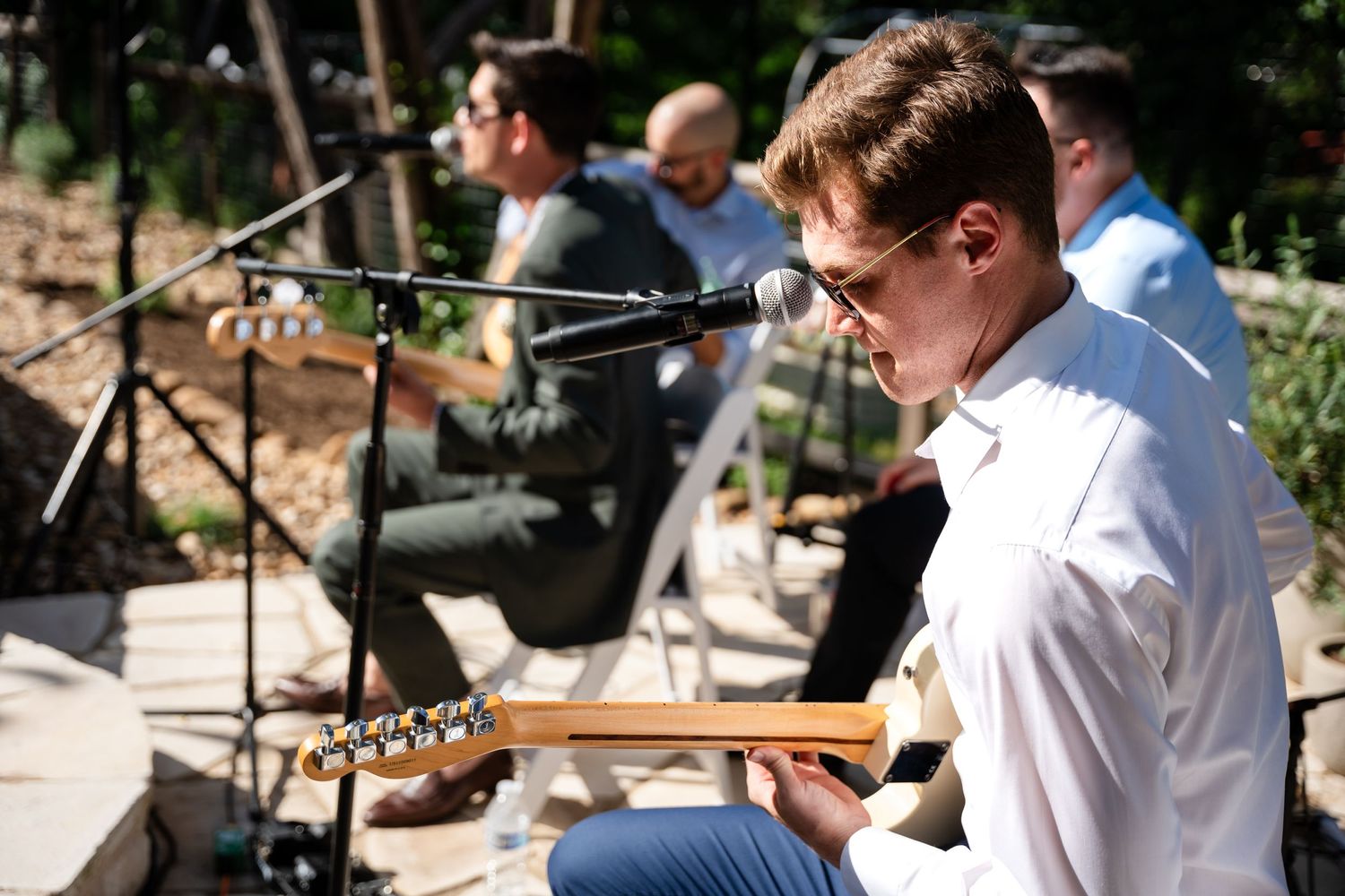 A musician playing guitar during an outdoor performance.