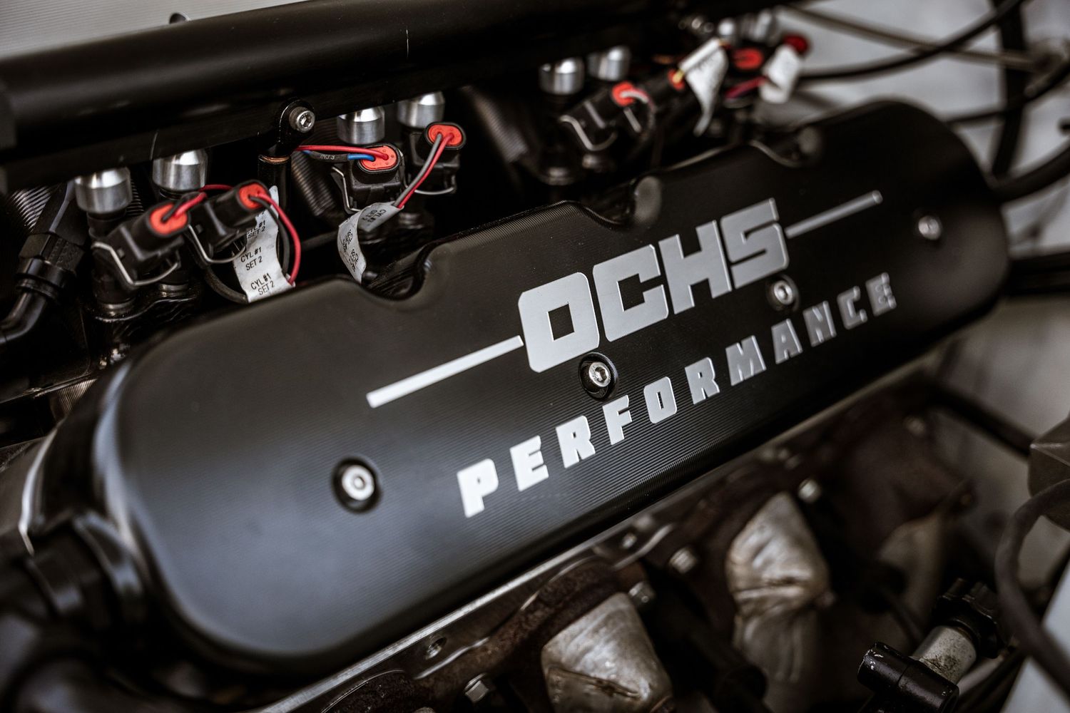 DCHS Performance black valve cover on a modified engine bay.
