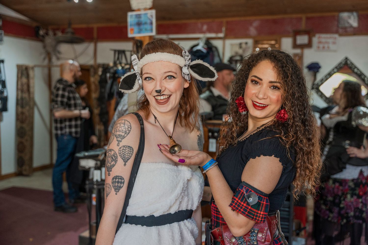 Two costumed festival attendees in vintage-style outfits pose together at a renaissance fair.