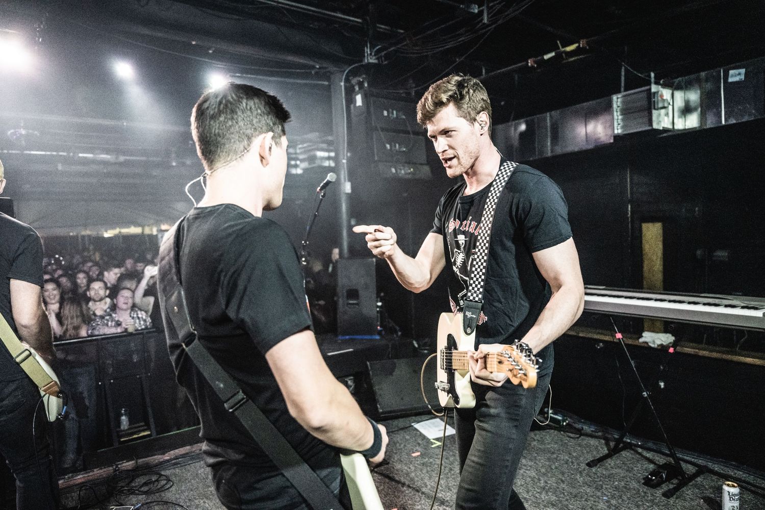 Musicians having animated discussion on stage during performance.