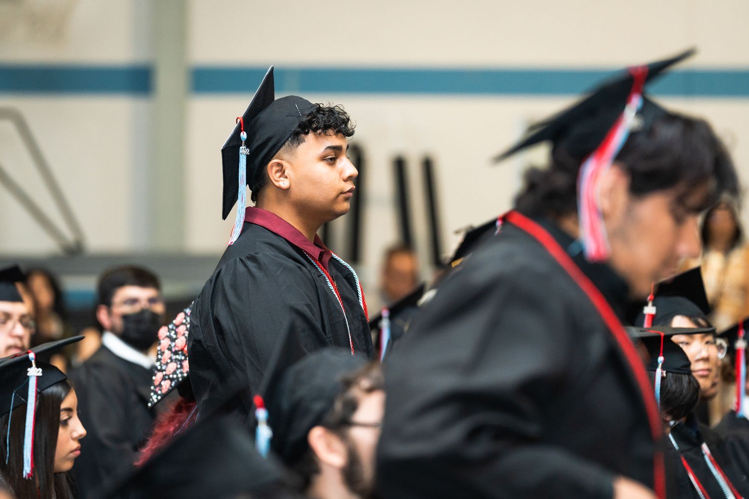Graduates wearing black caps and gowns at a commencement ceremony.