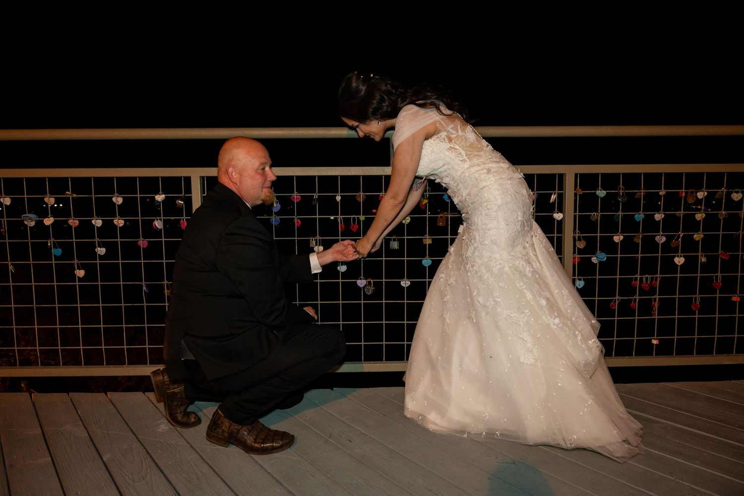 Romantic nighttime moment on an outdoor deck with string lights.