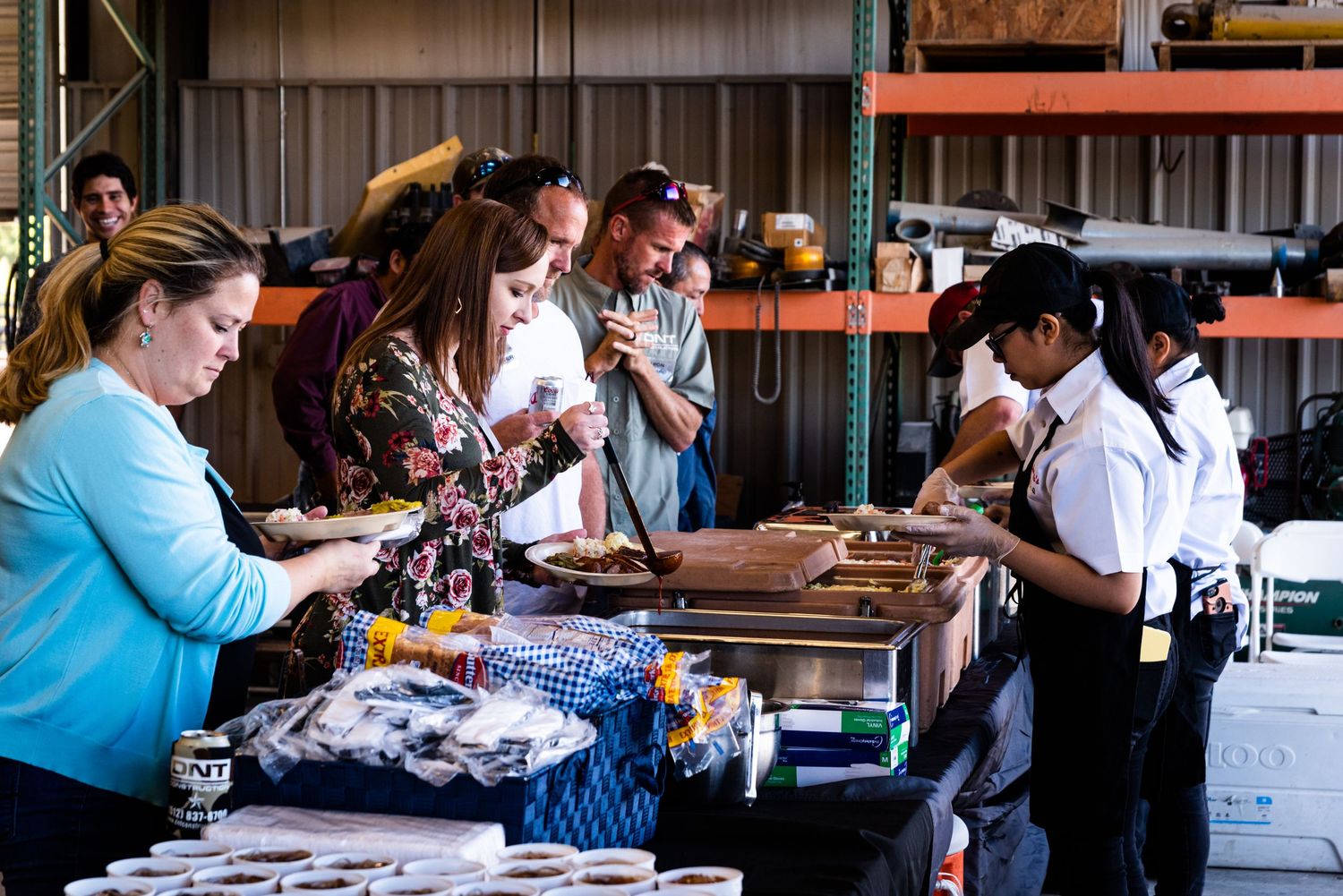 Group of people gathered around a table at an indoor event.
