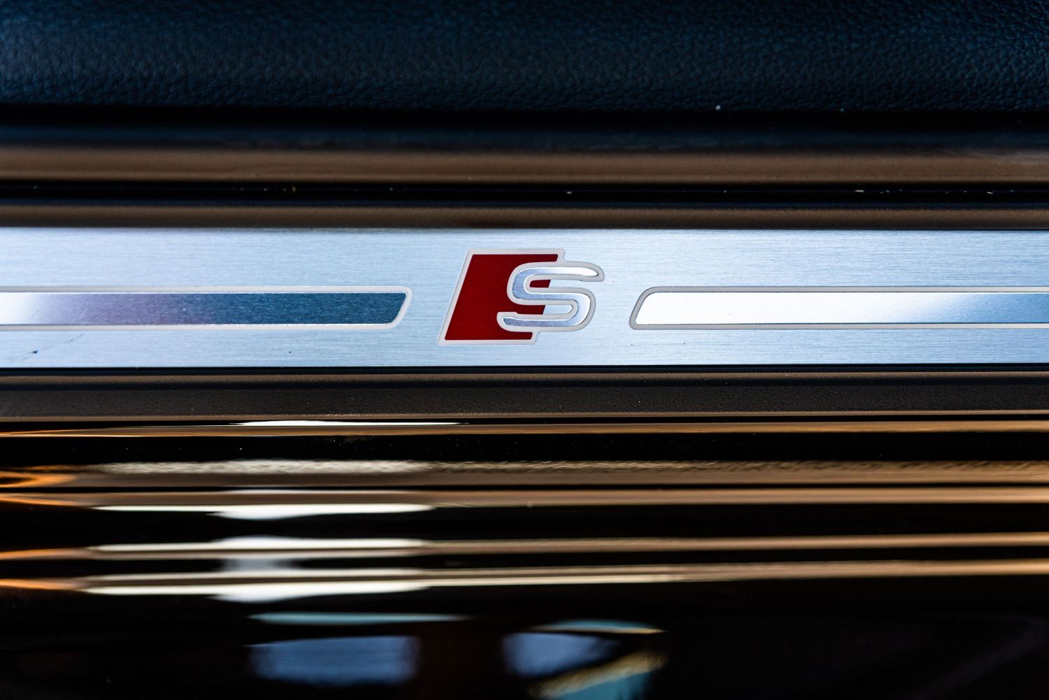 Close up of an Audi S-line door sill plate with metallic finish.