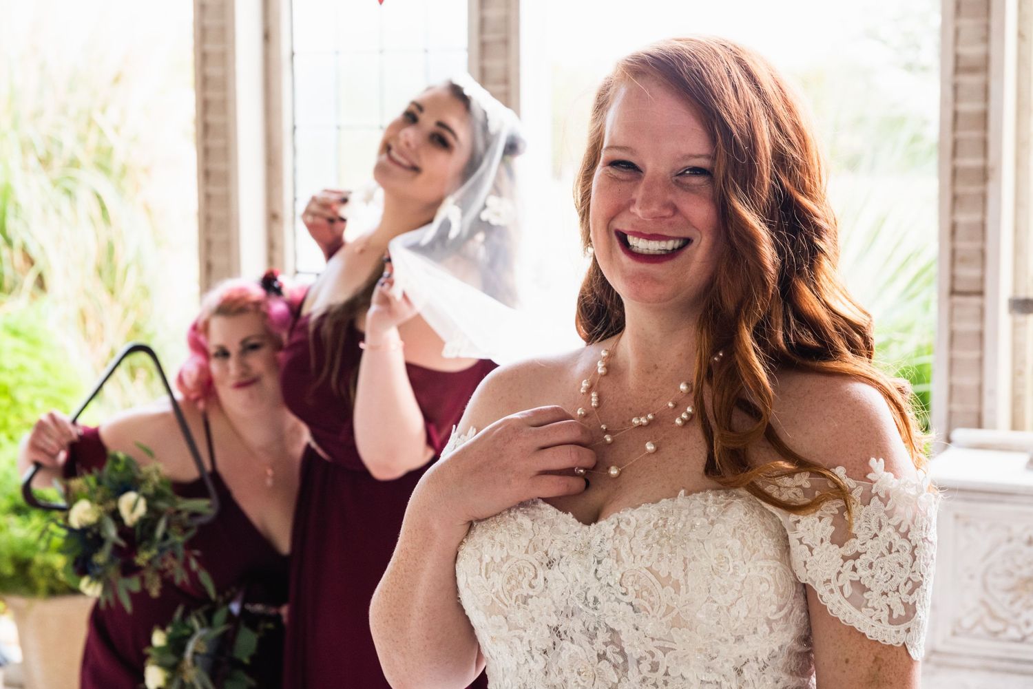 Candid laughter during bridal portraits in a sunlit chapel setting.