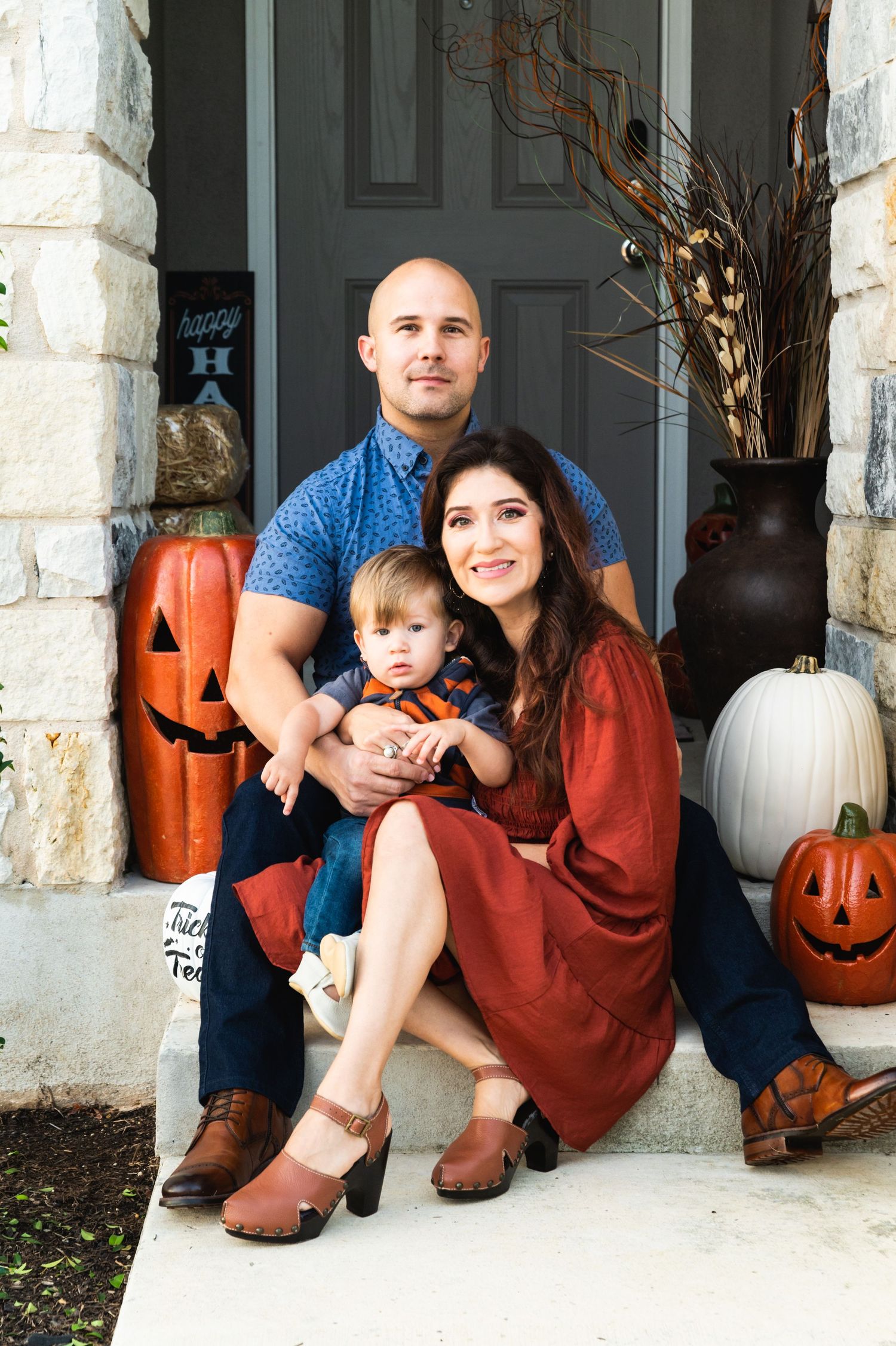 Fall themed front porch portrait with Halloween decorations and pumpkins.