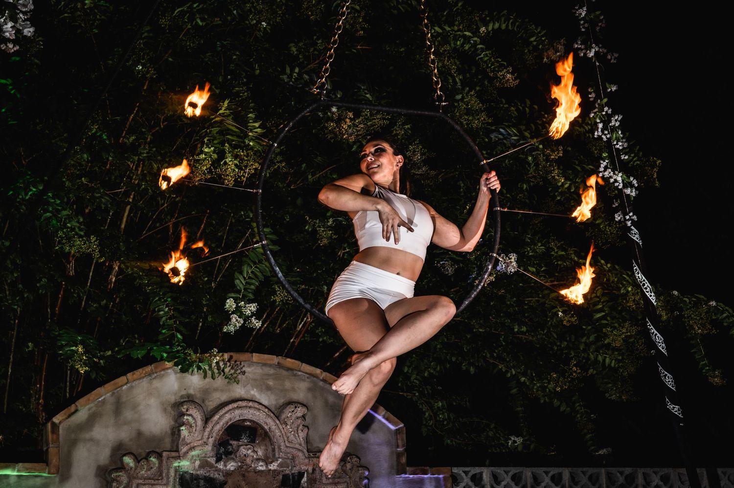 Artist performs dramatic dance moves against ornate backdrop with fire elements.