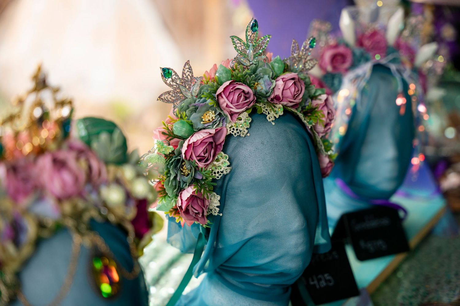 Turquoise ceramic vases adorned with delicate pink roses and floral arrangements create an elegant vintage display.
