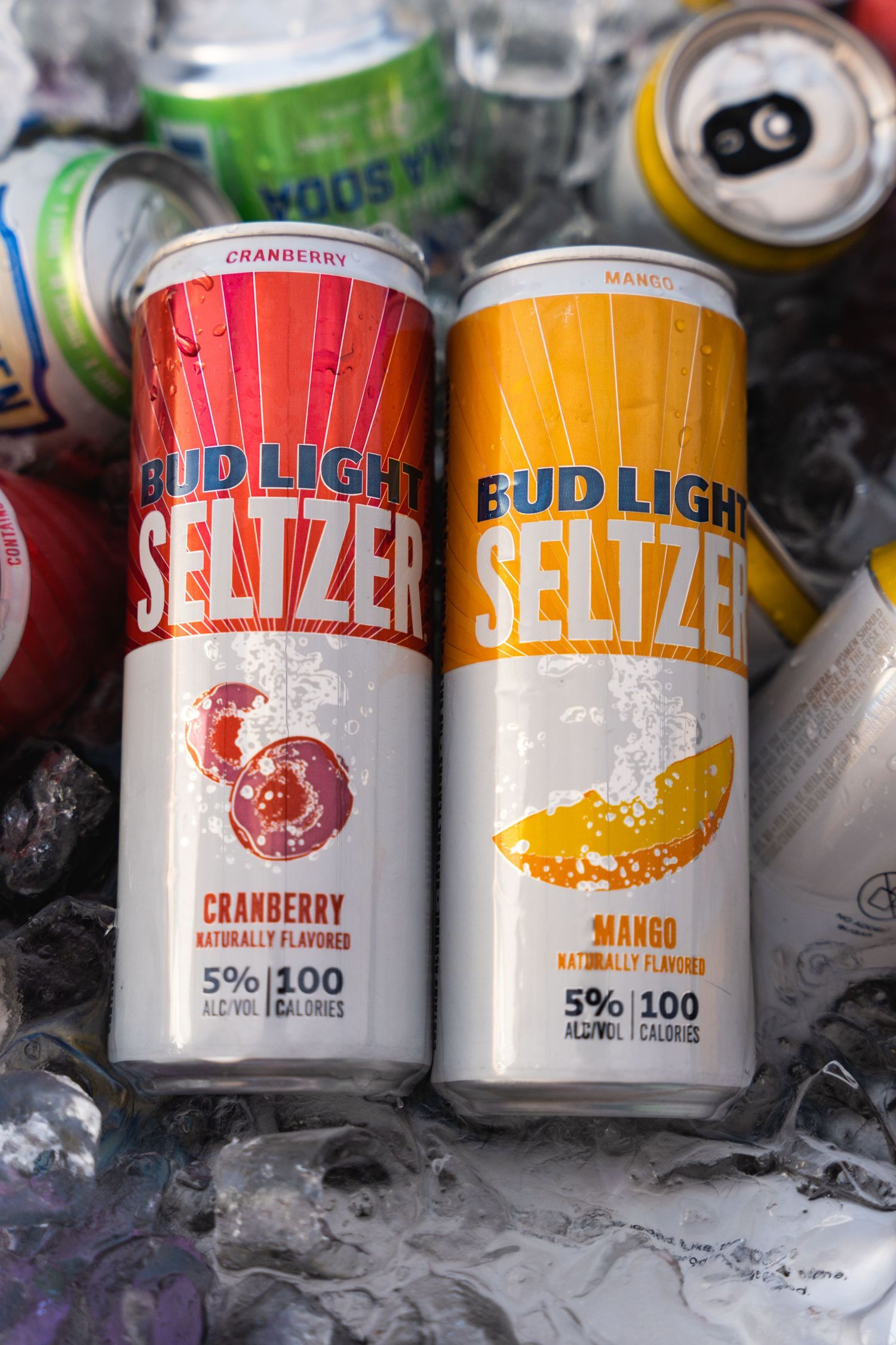 Bud Light Seltzer cans in cranberry and mango flavors chilling on ice.