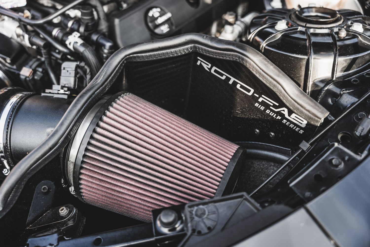 Performance air intake filter system installed in engine bay.