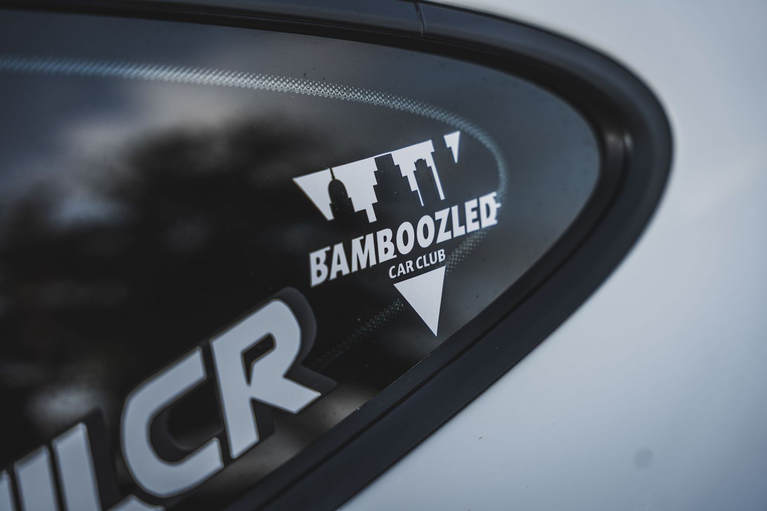 Close-up of Bamboozled performance decal on black automotive surface.