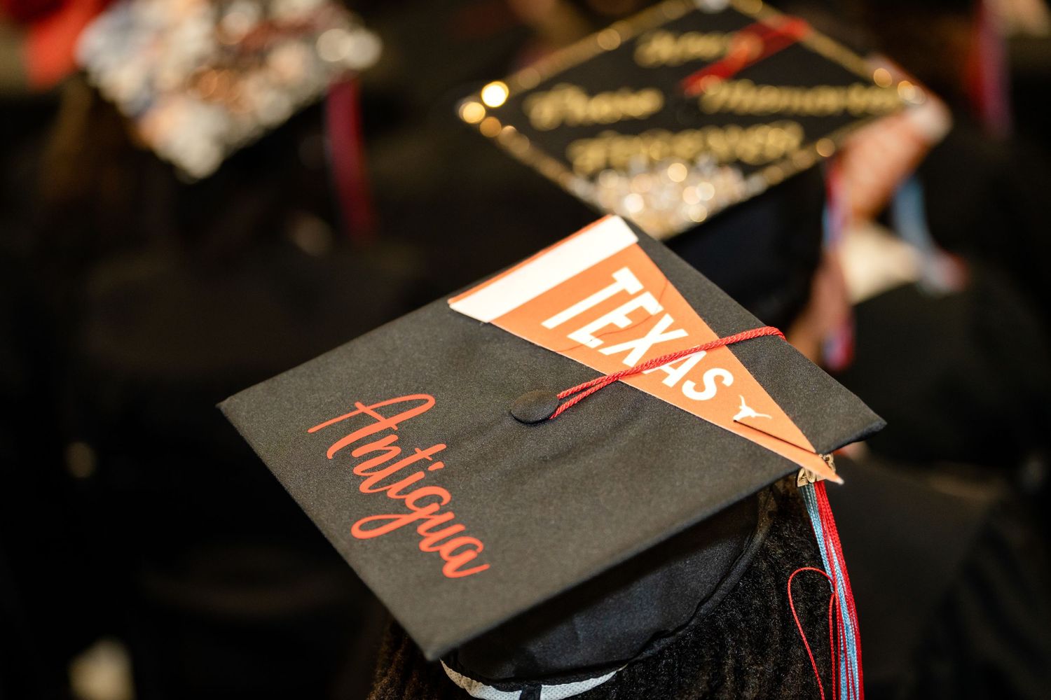 A graduation cap with a Texas pennant and tassel visible during commencement.