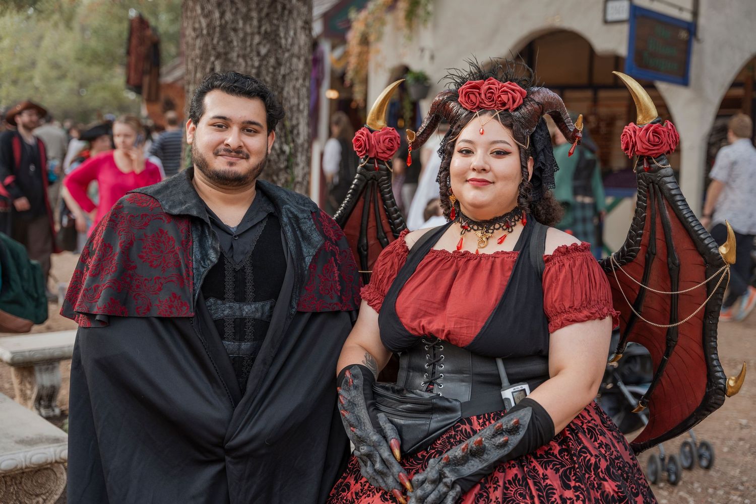 Couple in Gothic Victorian costumes posing at renaissance faire.