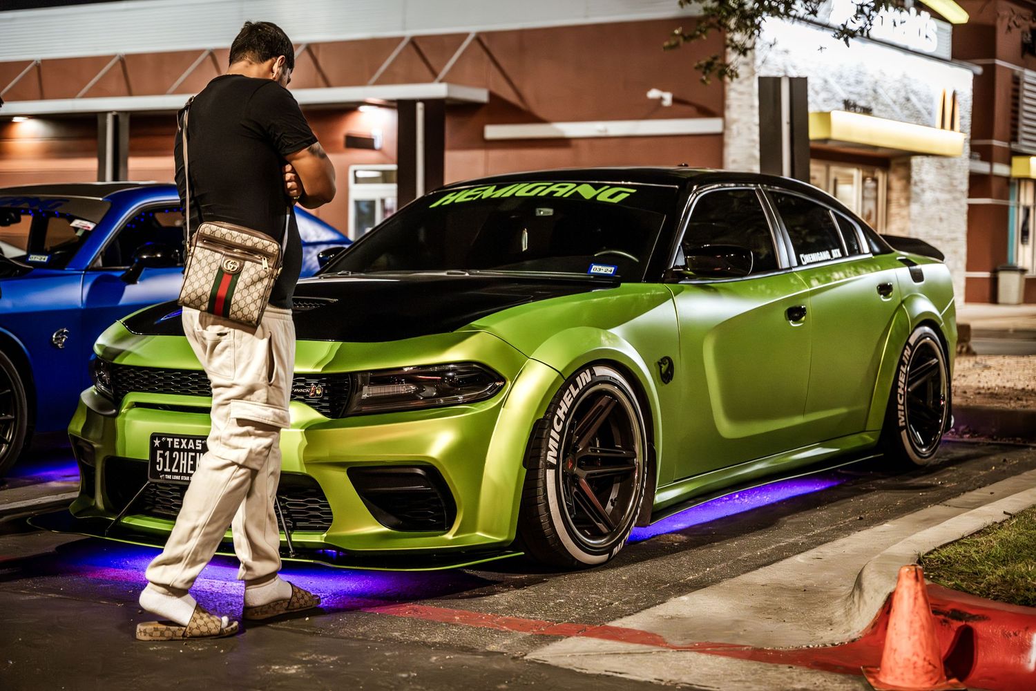 A bright lime green modified sports sedan with custom wheels and LED underbody lights.