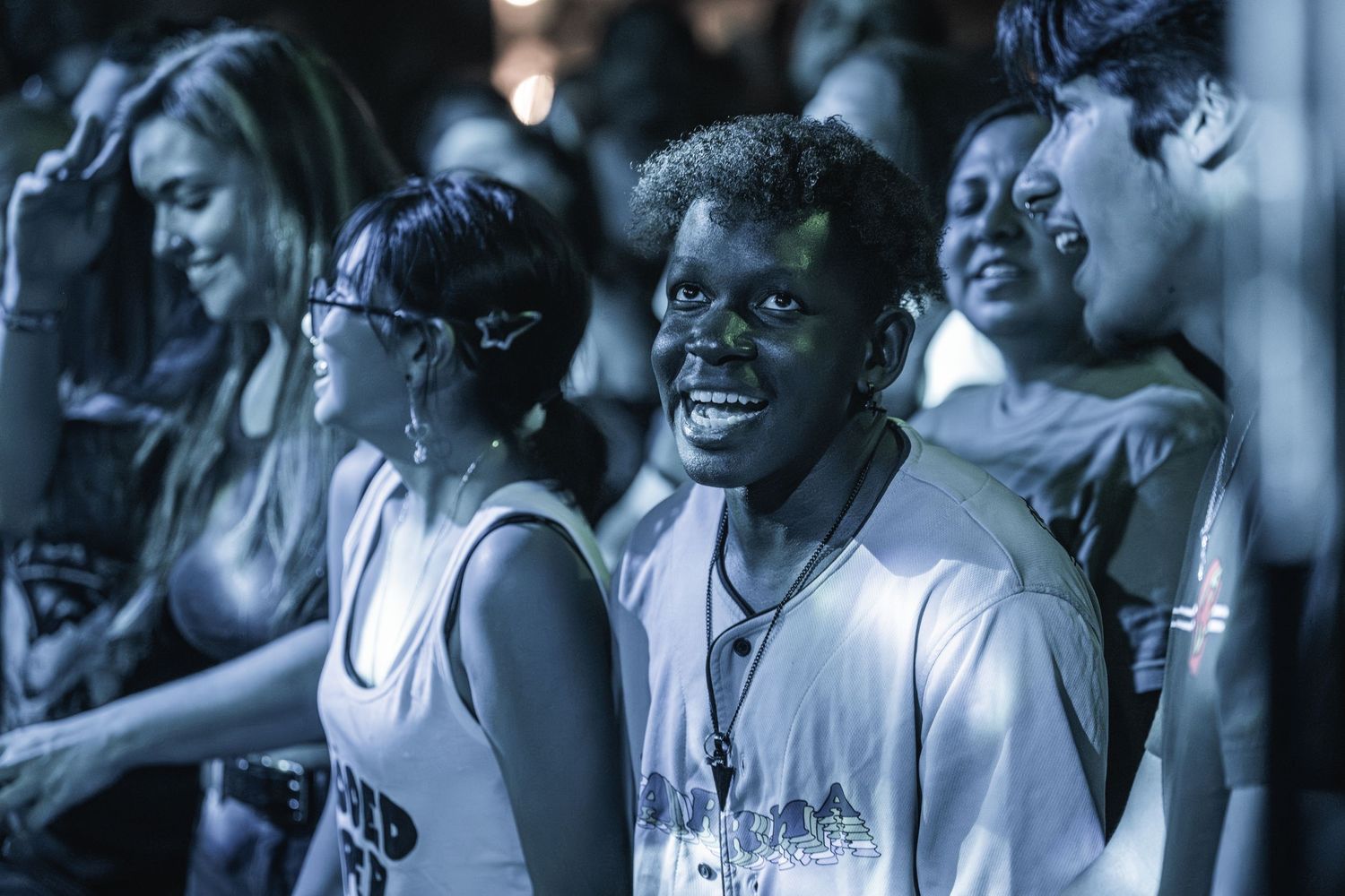 Concert attendees enjoying live music performance with joyful expressions.