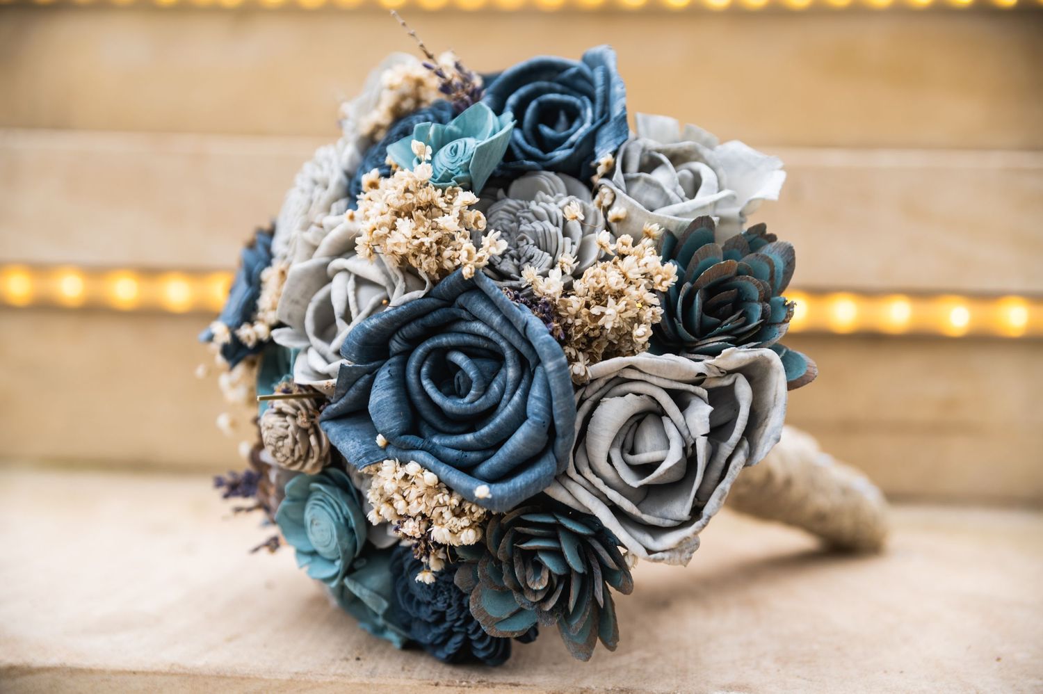 Bridal bouquet with navy blue and silver roses tied with rustic twine.