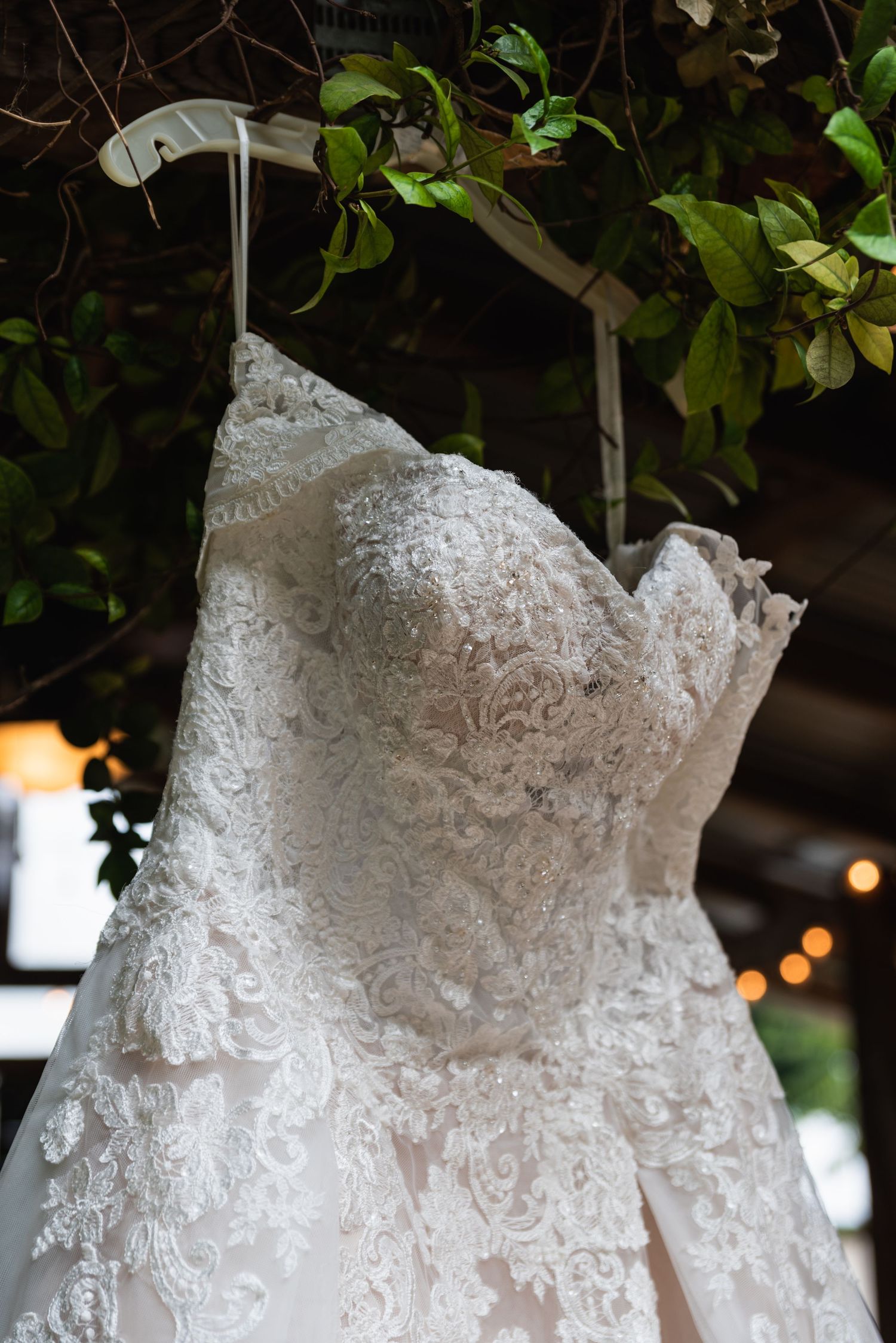 Close-up detail of delicate lace pattern on white wedding dress bodice.