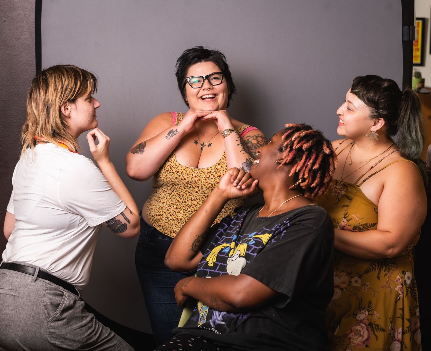 Candid shot of four friends laughing together during a fun photo session.