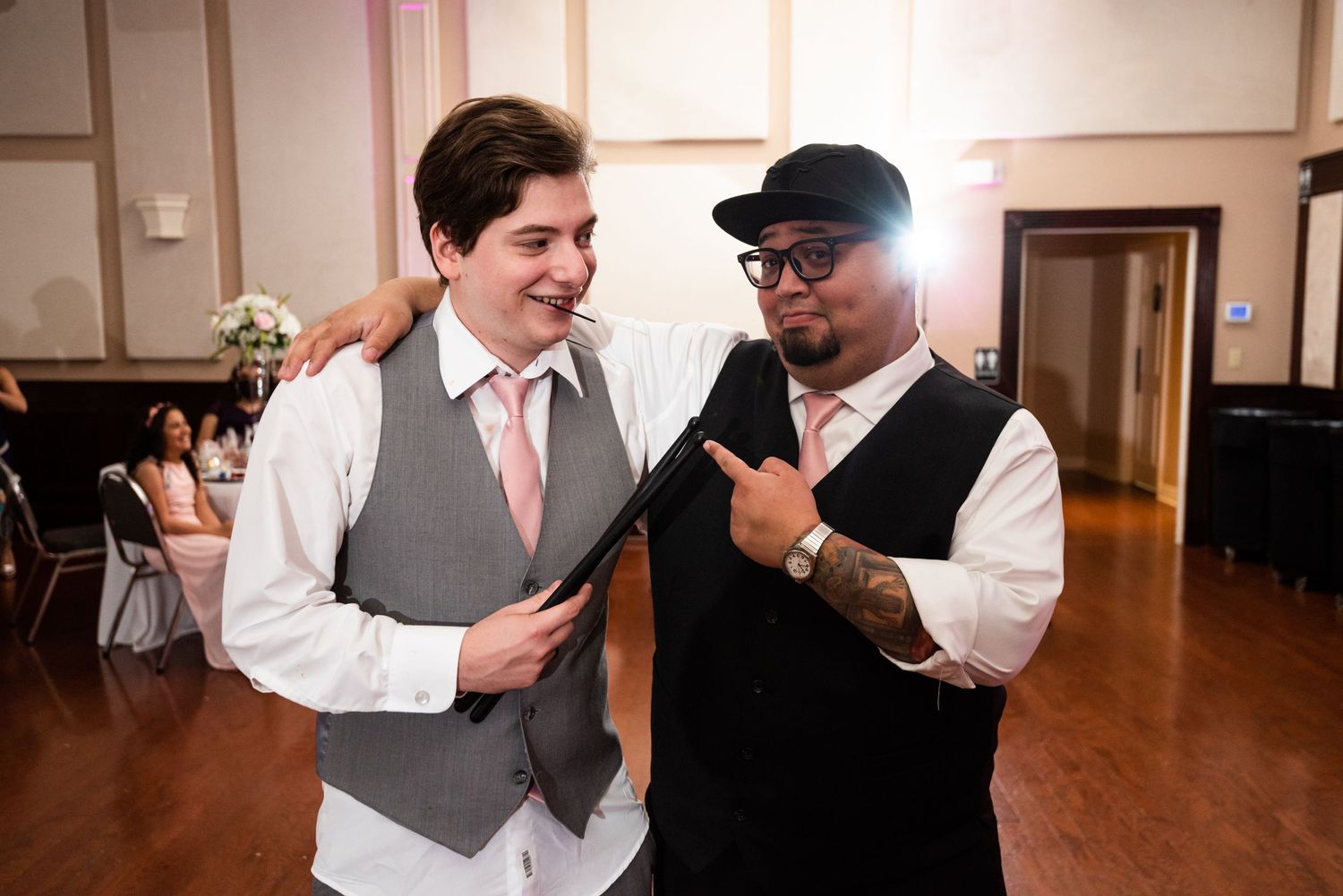 Two people share a lighthearted moment on the dance floor during a wedding reception.