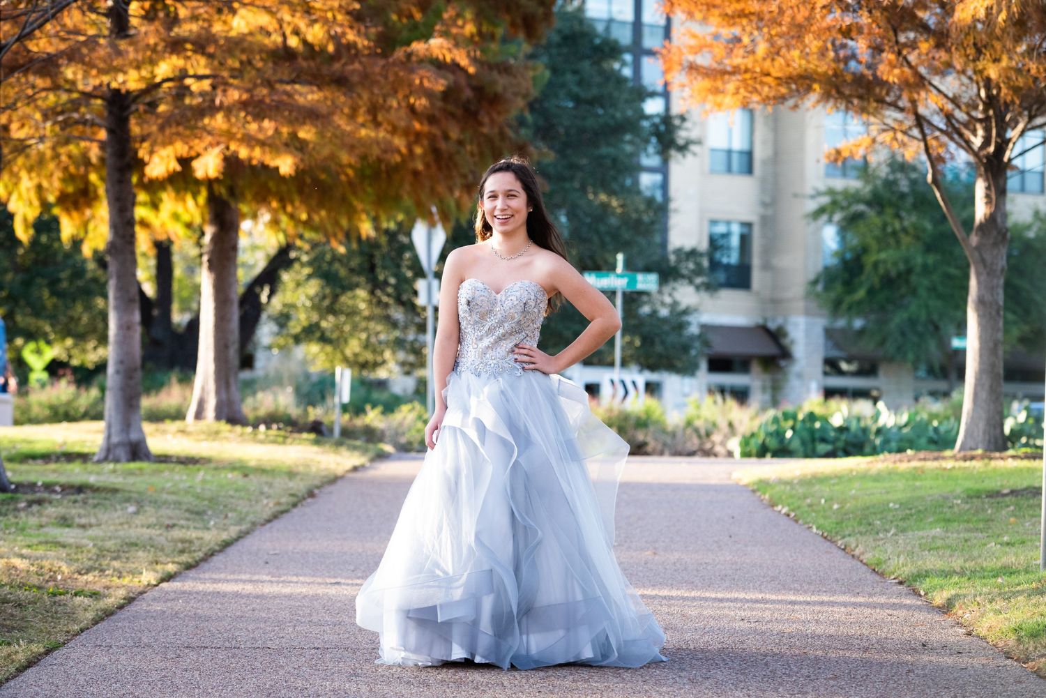 Light blue ballgown photographed on pathway with autumn foliage.