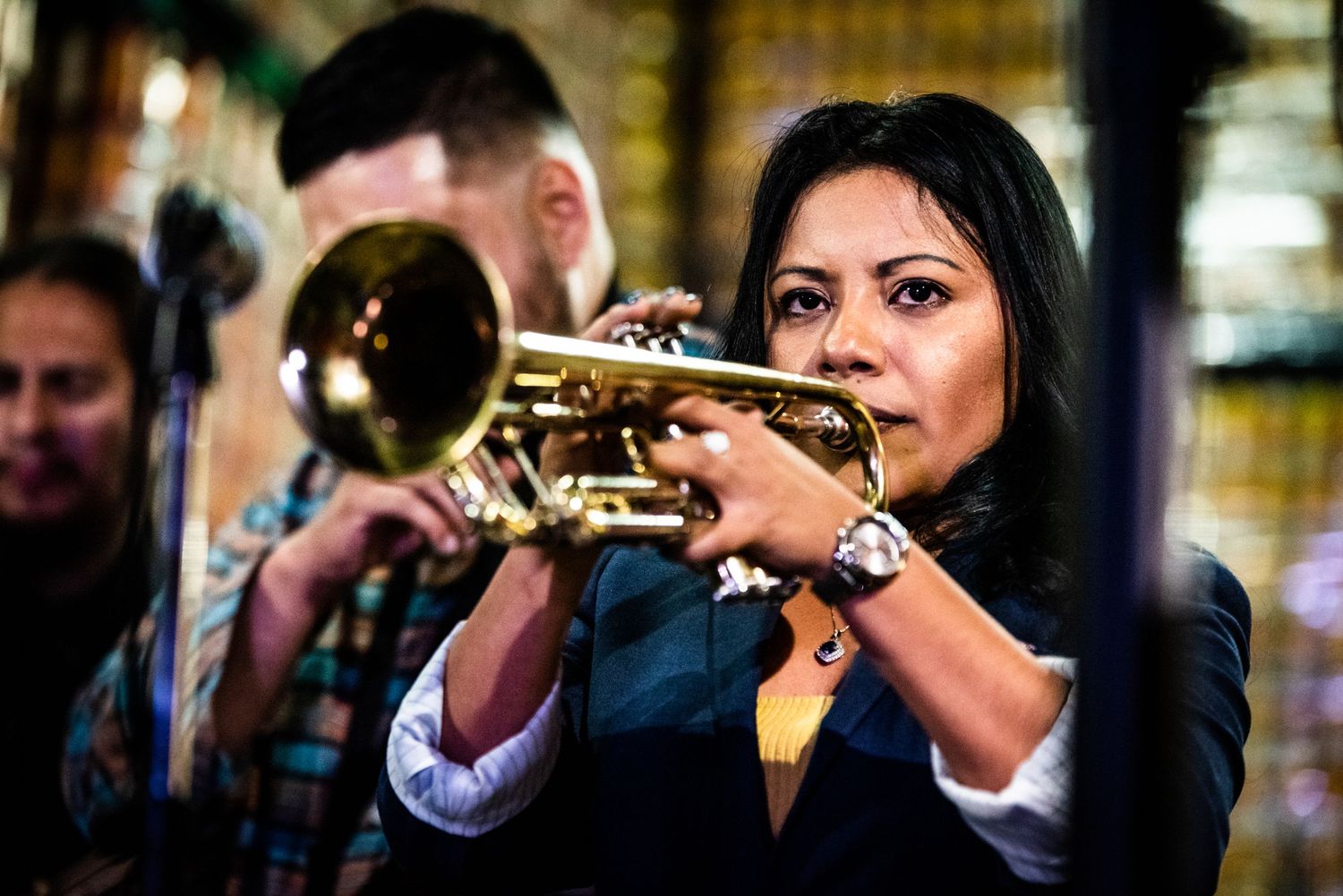Skilled musician plays trumpet during live jazz performance.