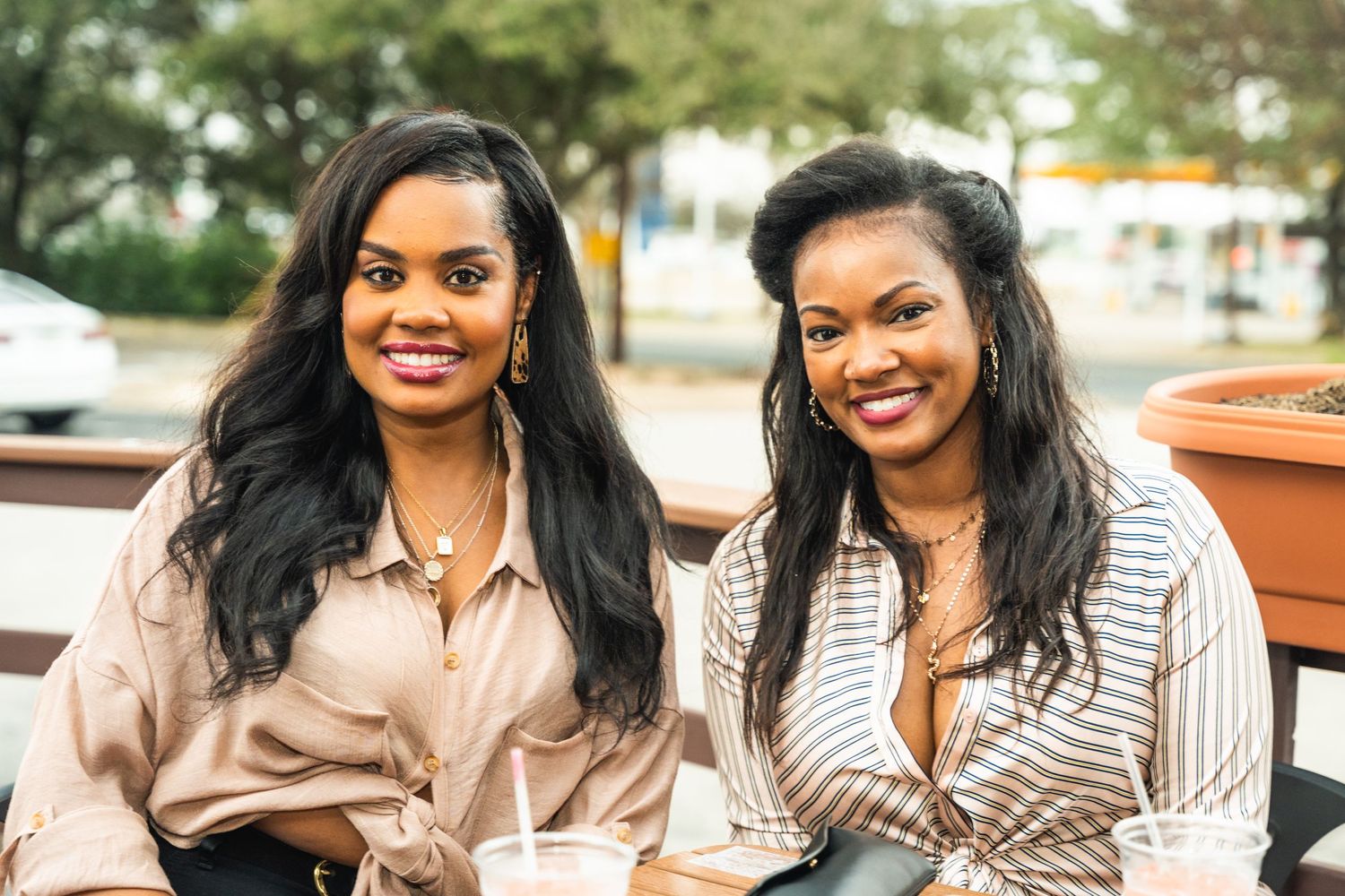 Two friends enjoying conversation at outdoor cafe table.