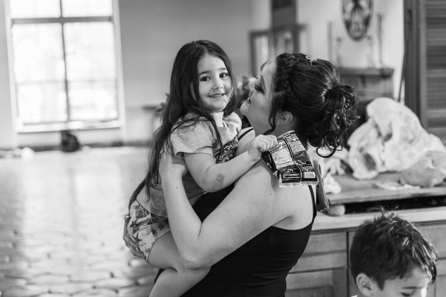 A tender moment shared between two figures in a black and white candid photo.