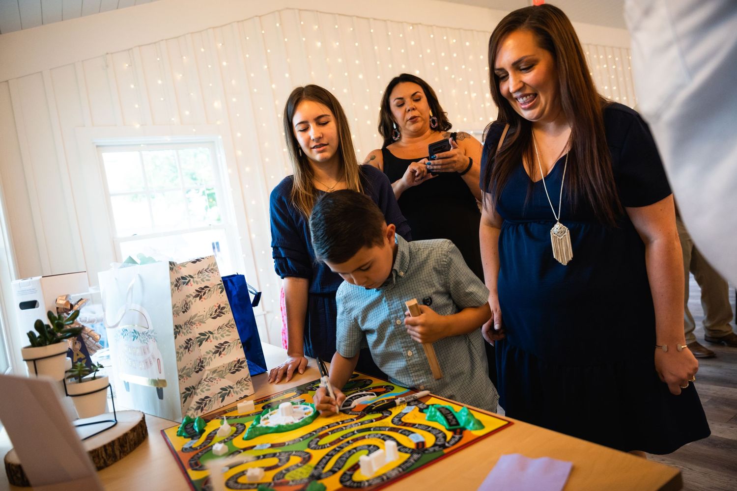 Group gathered around decorated cake at celebration party.