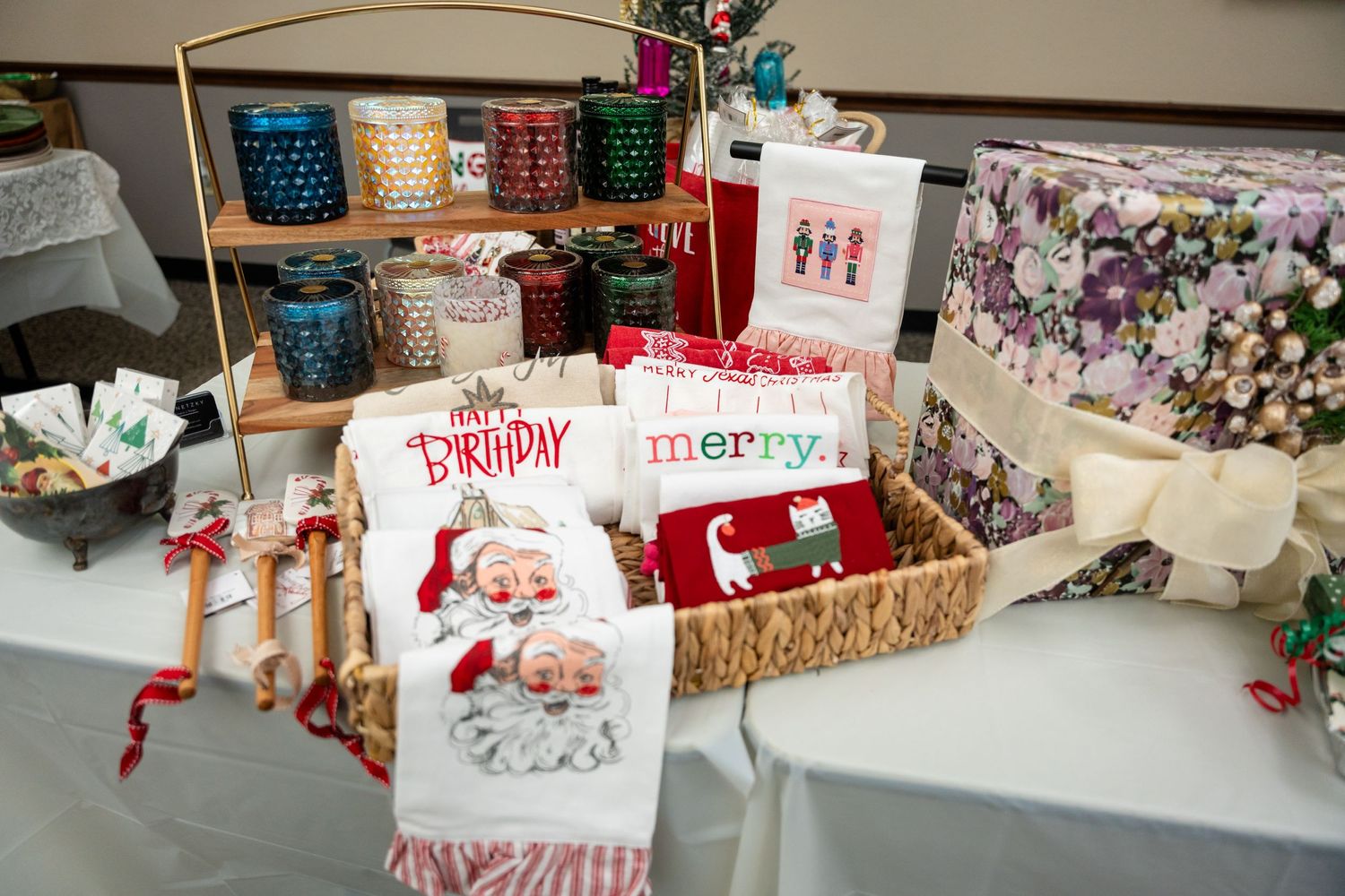 Holiday-themed dish towels and decorative items displayed in a retail setting with Christmas patterns.